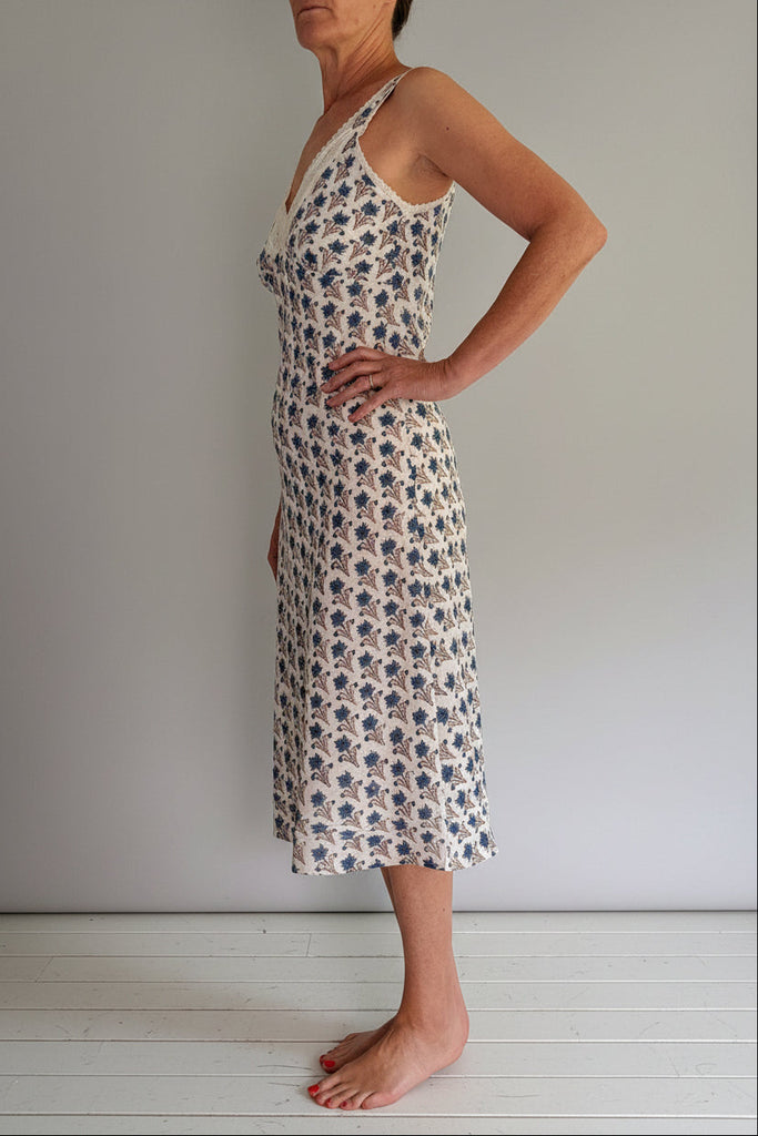 Woman wearing a floral dress against a plain background