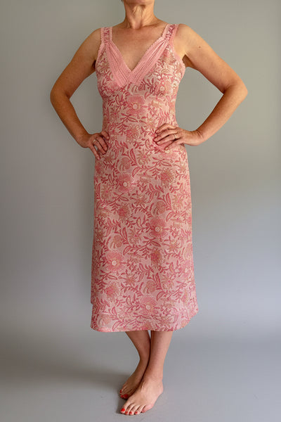 Woman wearing a pink floral dress against a white background