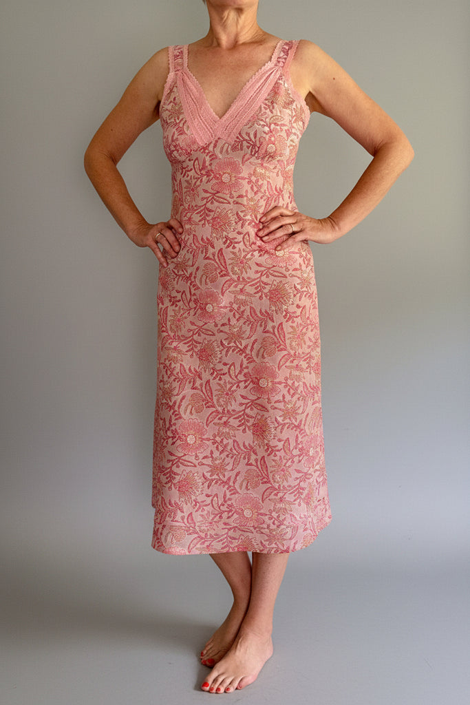 Woman wearing a pink floral dress against a white background