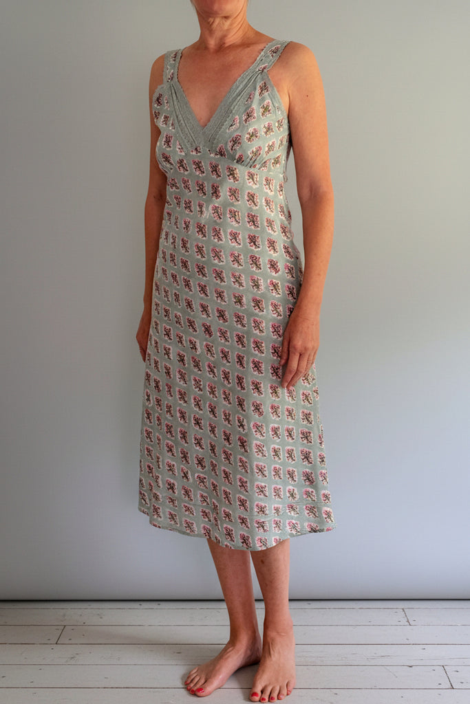 Person wearing a patterned dress against a plain background