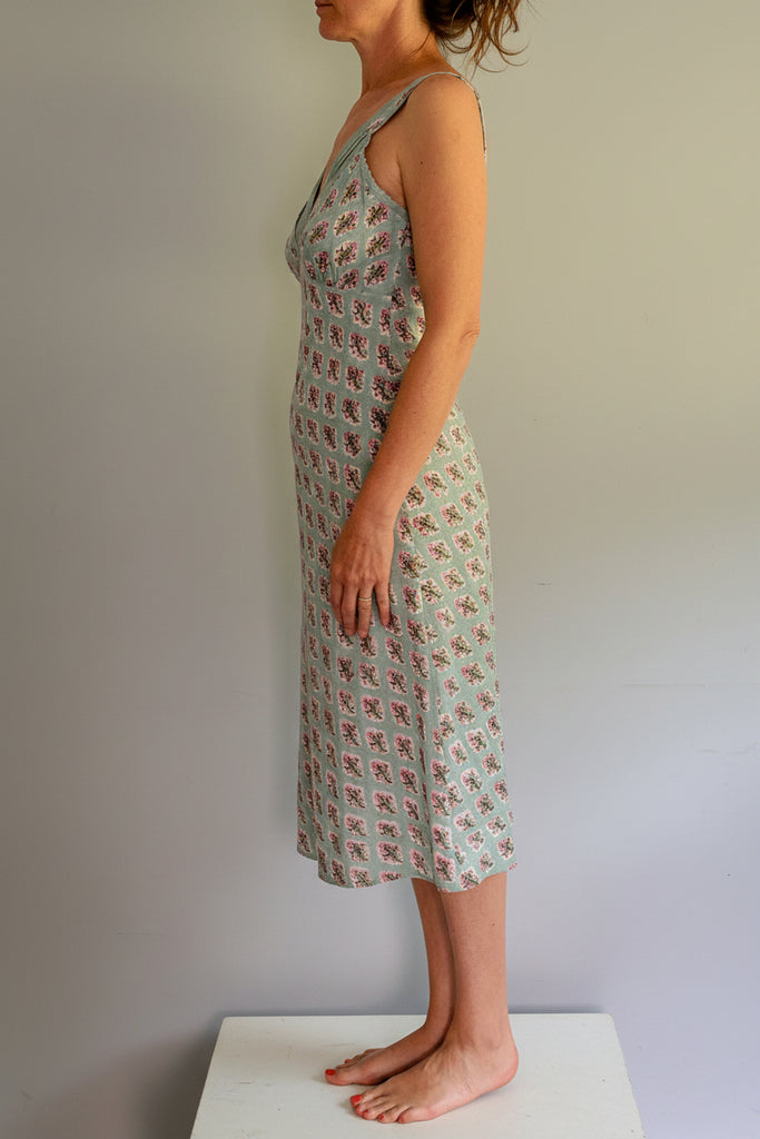 Woman wearing a patterned dress against a plain background