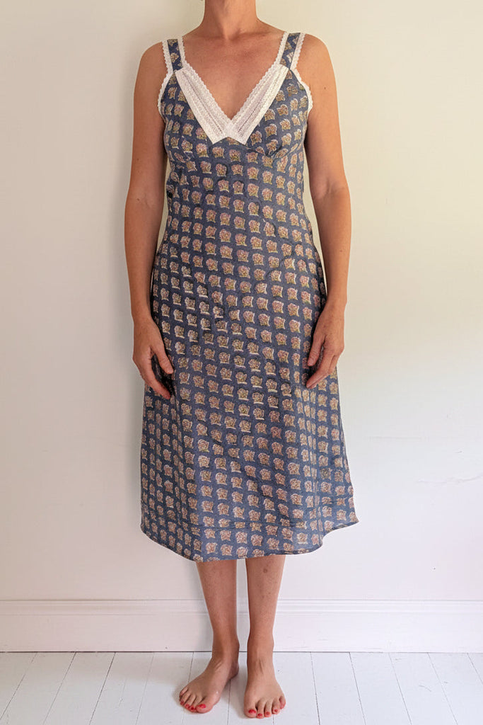 Woman wearing a patterned dress against a plain background