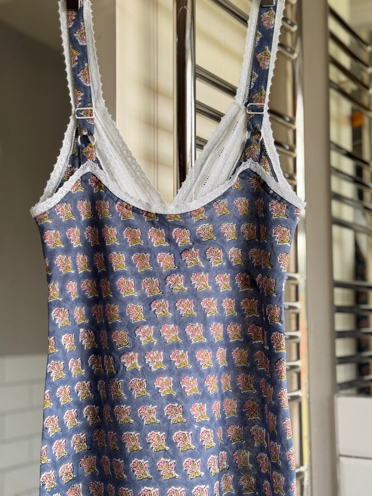 Blue patterned dress with lace trim hanging on a rack.