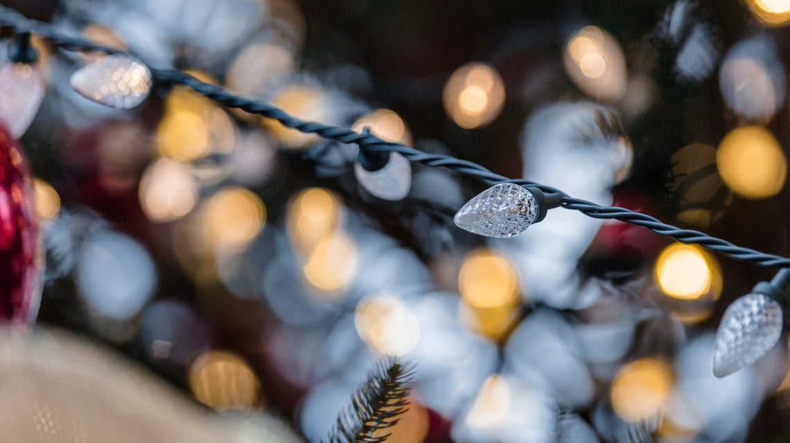 Decorative string lights with snowflake ornaments on a blurred festive background