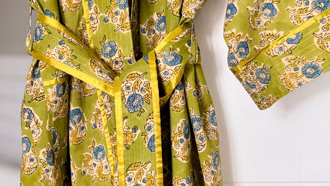 Green floral-patterned robe with yellow trim on a white background