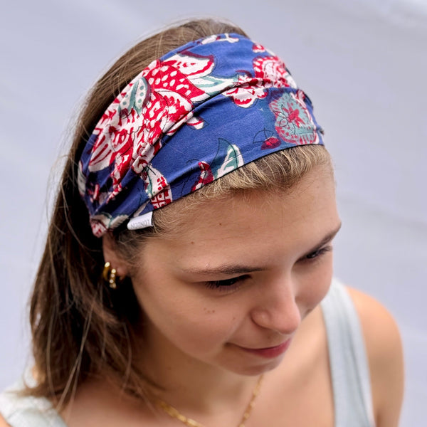 Woman wearing a colorful headband with a pattern on a plain background