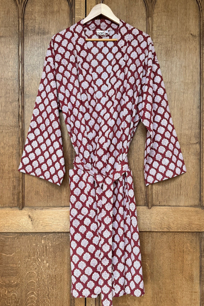 Red and white patterned men's kimono on a wooden hanger against a wooden background