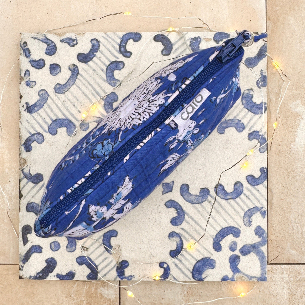 Blue cosmetic bag with floral design on a textured surface