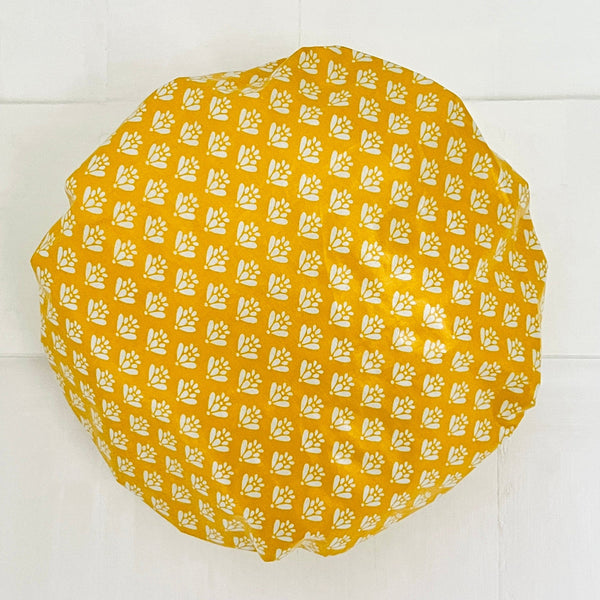 Yellow patterned fabric on a white tiled background