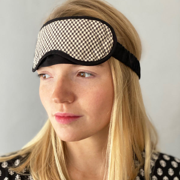 ladies quilted cotton eye mask in black and cream small scale geometric print with black trim adjustable strap and bound edging by caro london