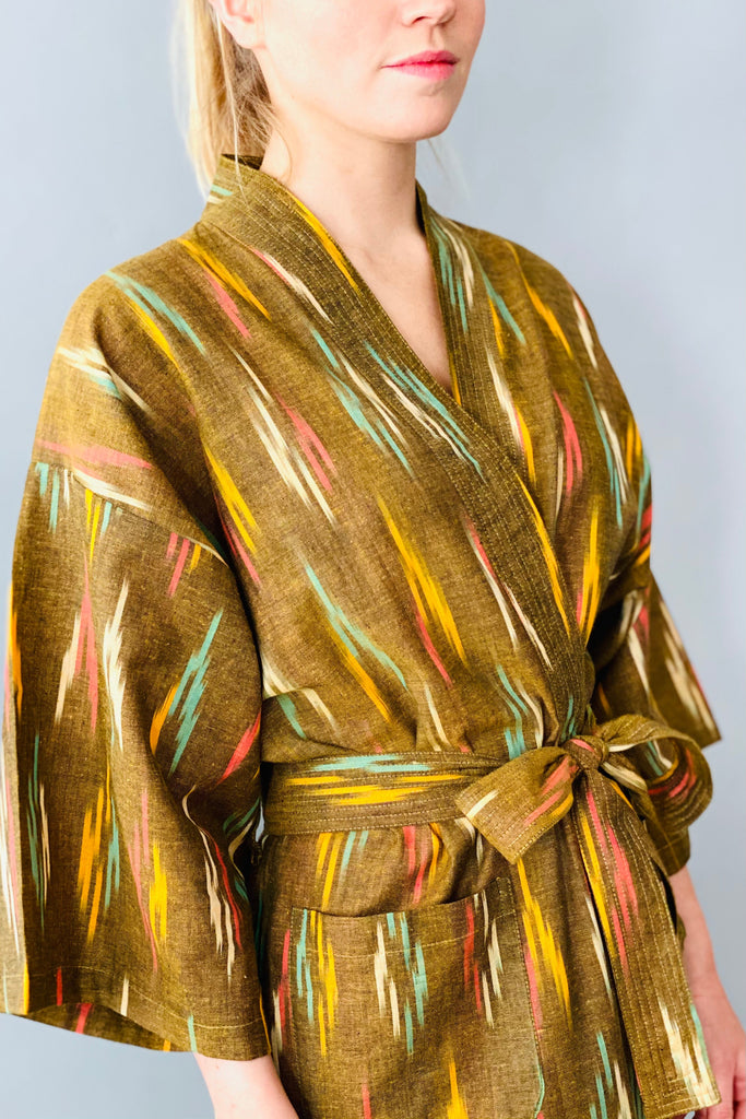 Woman wearing a patterned robe against a plain background