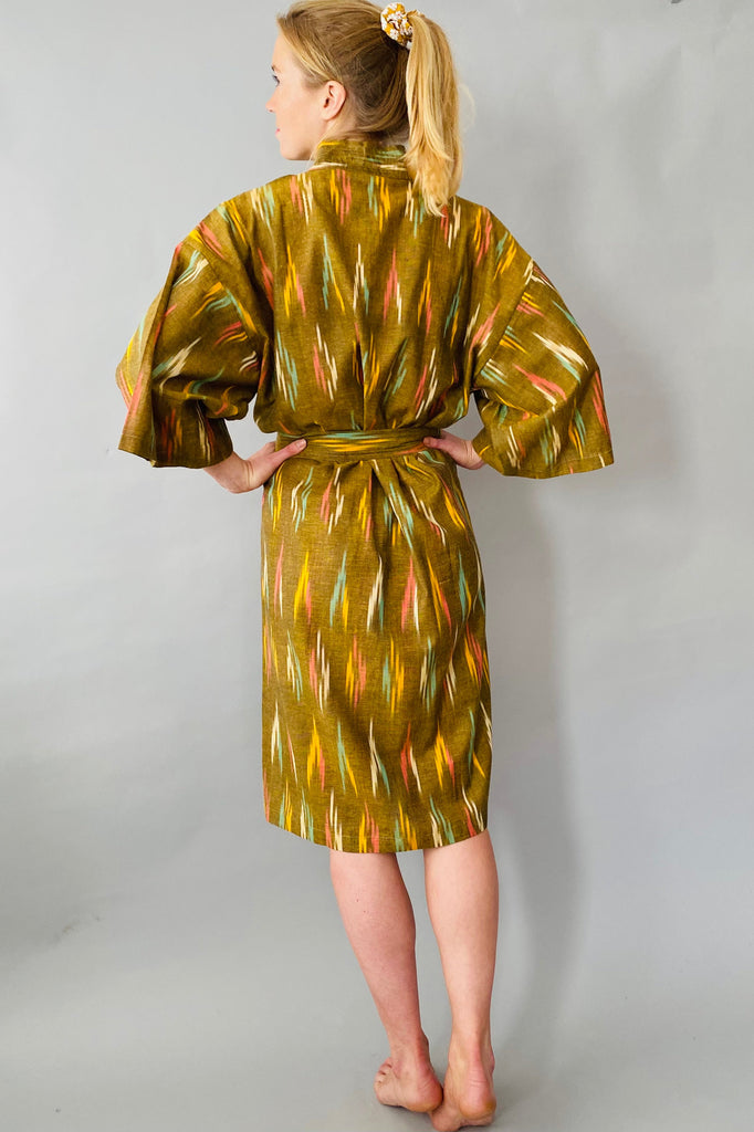 Woman wearing a patterned robe against a plain background